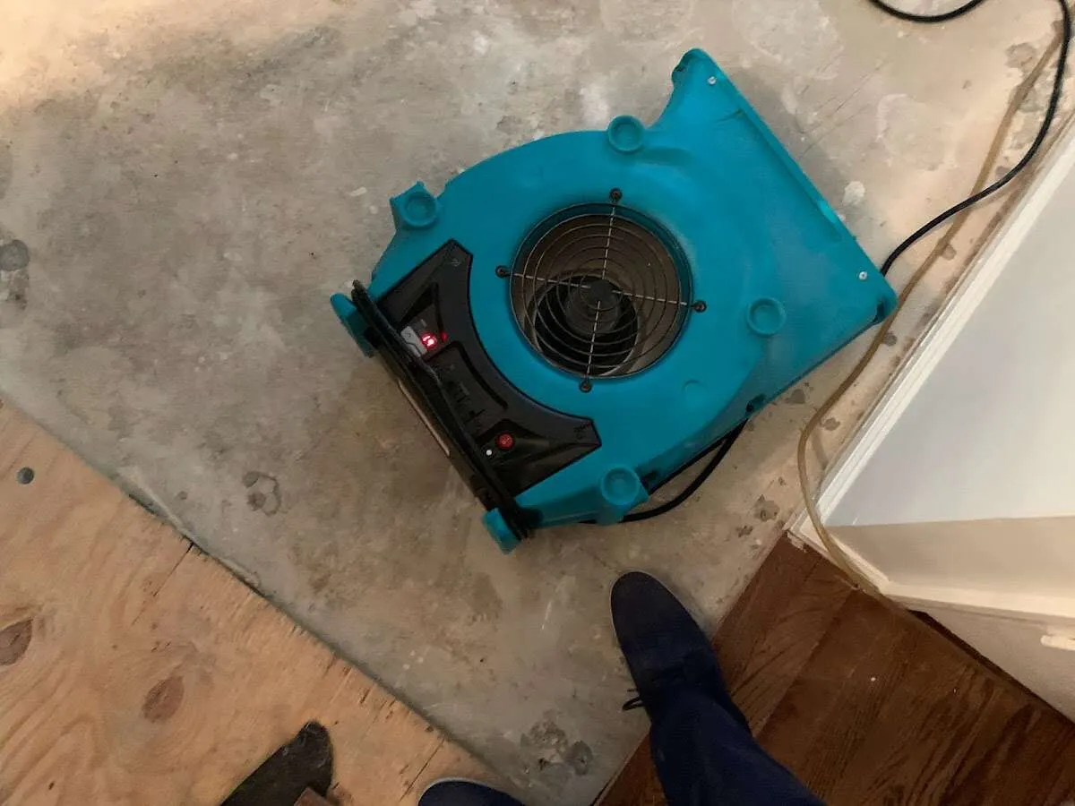 Air mover drying subfloor during Commercial Water Damage Restoration in Bryant